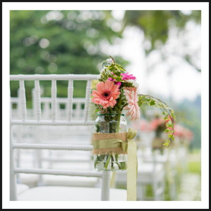 Wedding RentalsFlowers on the back of a chair at a wedding